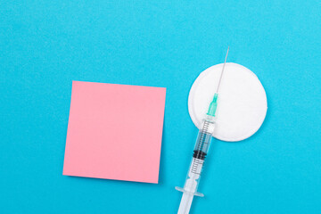 Vaccination, Immunology or Revaccination Concept - A Medical Disposable Syringe Lying on Blue Table...