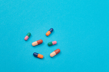 Global Pharmaceutical Industry and Medicinal Products - Colored Pills or Capsules Scattered on Blue Background