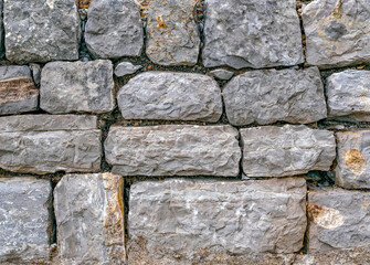 Ancient wall masonry from chipped granite blocks. Wall stone pattern.