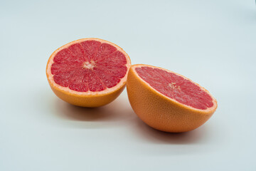 Fototapeta na wymiar Two half juicy and delicious grapefruits on white background