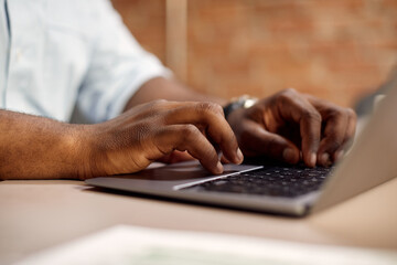 Close-up of black businessman types on computer while working in the office.