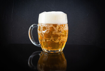 Mug of light beer on dark background. Craft unfiltered beer