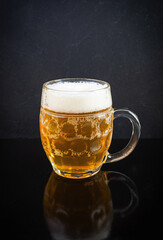 Mug of light beer on dark background. Craft unfiltered beer