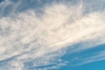fluffy gentle clouds slowly and hopelessly float across the endless sea of blue sky. Clear blue sky after the raging elements and storms.