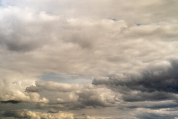 Beautiful fluffy clouds in the evening sky. The sunlight gives a side light on the clouds. Clouds before rain.