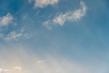 fluffy gentle clouds slowly and hopelessly float across the endless sea of blue sky. Clear blue sky after the raging elements and storms.