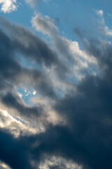 Fototapeta premium Beautiful fluffy clouds in the evening sky. The sunlight gives a side light on the clouds. Clouds before rain.