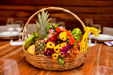 Fototapeta na wymiar basket of fresh fruit and flowers on the table 