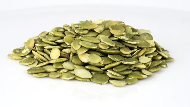 Pile of yellow-green sunflower seeds rotating, close-up 360 degrees loop, 30 fps