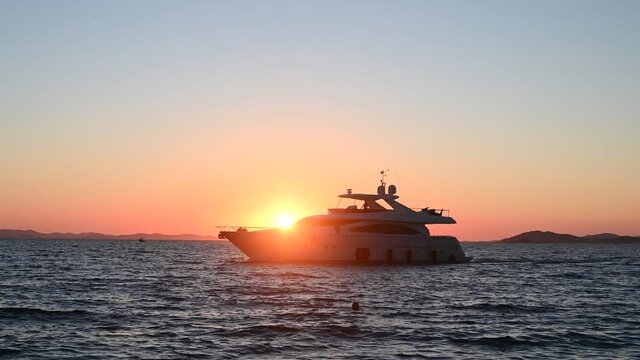 The silhouette boat at sunset. The boat on the sea. Speed boat is running on deep blue sea.