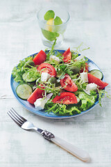 Salad with Green Olives, Tomatoes and Feta Cheese. Bright wooden background. Close up. 