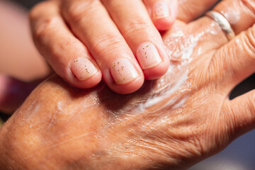 Fototapeta premium Young woman rubs cream into her hands.