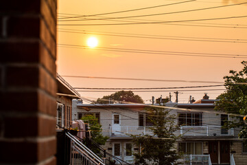 Vue sur des résidences sur un coucher de soleil avec ciel orangé et smog dans l'air