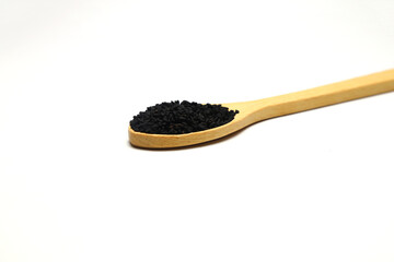 Nigella sativa or Black cumin in wooden spoon isolated on white background