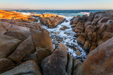 Obraz premium rocks and sunlight next to the water on the coast