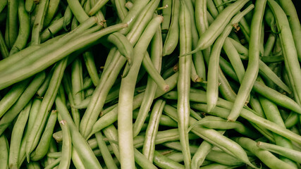Green string beans on shelf stacked texture background