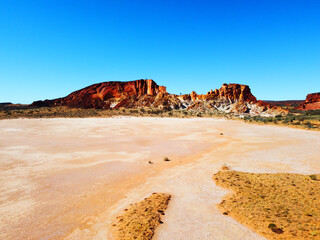 Fototapeta na wymiar Amazing Rainbow Valley in Northern Territory, Australia, just outisde Alice Springs. Beautiful red and orange rock formation with blue sky and orange sands