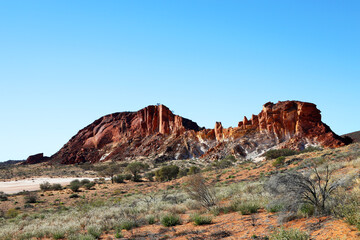 Fototapeta premium Amazing Rainbow Valley in Northern Territory, Australia, just outisde Alice Springs. Beautiful red and orange rock formation with blue sky and orange sands