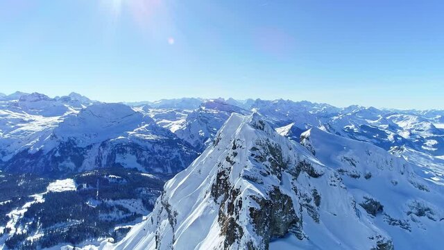 Aerial view of the Swiss Alps in winter, rolling mountains covered by heavy snow