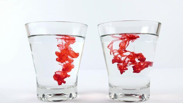 Pour red food coloring into a glass of hot water on the left and cold water on the right. Diffusion science concept