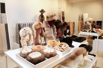 Winter women's hats made of natural fur on the window of boutique