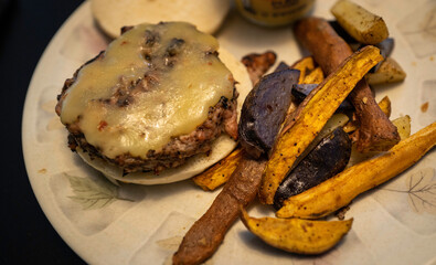 Homemade Chicken mushroom burger with cheddar cheese on muffin served with mixed regular and sweet potatoes 