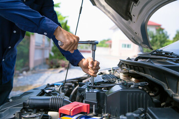 Car care maintenance and servicing, Close-up hand technician auto mechanic using the wrench to...