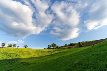 The beauty of the large fresh green fields on the high mountains and the blue sky, giving a feeling of relaxation.