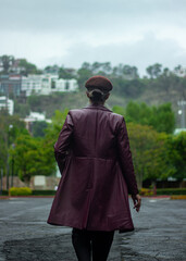 mujer con gabardina caminando de espaldas