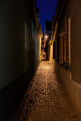 Fototapeta na wymiar Dark narrow street alley human silhouette walking