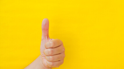 
Hand with thumb up on yellow background