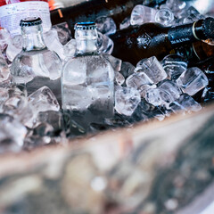 Close up of basket with ice and beer and water bottles - concept of party and catering event