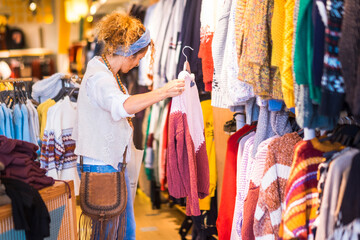 Woman inside a clothes stores in complusive shopping activity - trendy fashion lifestyle people - concept of sales occasion discount mall commercial center and people buying