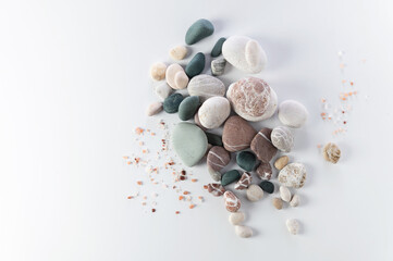 body and soul care banner, colored round stones, sea salt on white background, top view, empty space for text