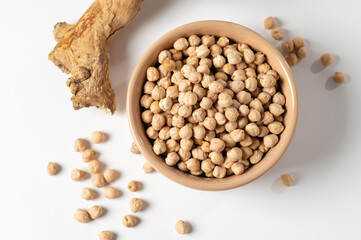dry chickpeas, in a ceramic dish on a white table, top view, close-up