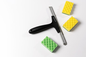 cleaning tools, scraper, window nozzle and colored washcloths on a white background