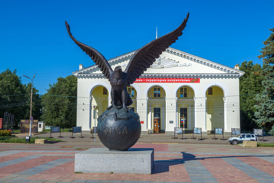 EAGLE, RUSSIA - JULY 06, 2021: Sculpture of a eagle on the globe against the background of the House of Culture of railway workers. Monument in honor of the 450th anniversary of the city of Orel