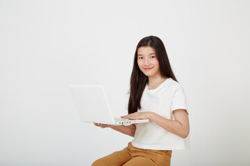 woman with laptop computer sitting cross legged and looking