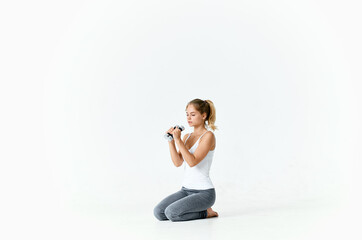 Obraz premium woman with dumbbells in her hands sitting on the floor exercise gym