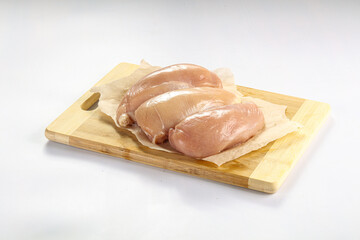 Raw chicken breast fillet over board