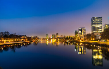 Night view of Frankfurt, Germany, with brightly lit buildings reflected in the nice Main River