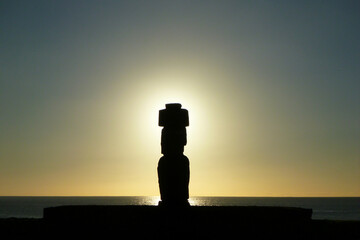 チリ・イースター島のプナパウにて夕日前の太陽と頭上にプカオを乗せたモアイ像のシルエット