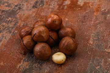 Brown macadamia nut heap over background