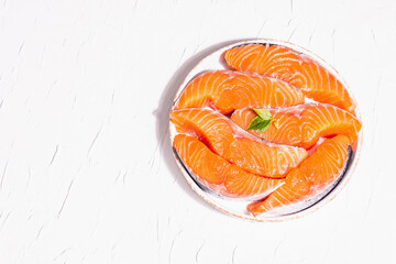 Fresh raw salmon or trout fish fillet steaks. Minimalistic design, modern hard light, dark shadow