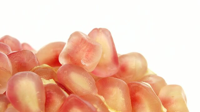 4K Organic healthy red fruit close-up. Open pomegranate fruit rotates on a white  background. Pomegranate seeds.