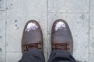 Winter season,snowing outside,The shot of two pairs of winter shoes covered with snow is made from the top view,Close up of snowflake structure,A couple in winter boots
