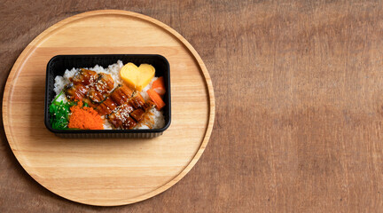 Teriyaki eel over rice on a wooden tray