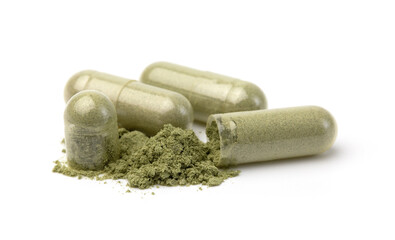 Close up, Andrographis Paniculata powder and capsules or herbal capsules isolated on a white background used to treat fever.