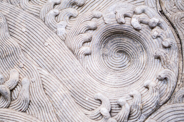 The stone is carved into a wave of water,Close-up of spiral pattern carved in rough stone,golden ratio.