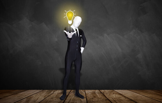 man in a morphsuit with a lightbulb in front of a blackboard